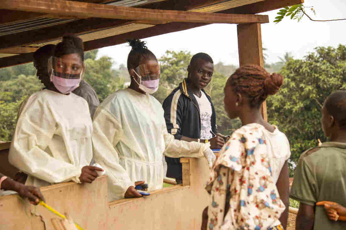 Health workers in Sierra Leone check travelers entering the country from Liberia. Zoom Dosso/AFP/Getty Images